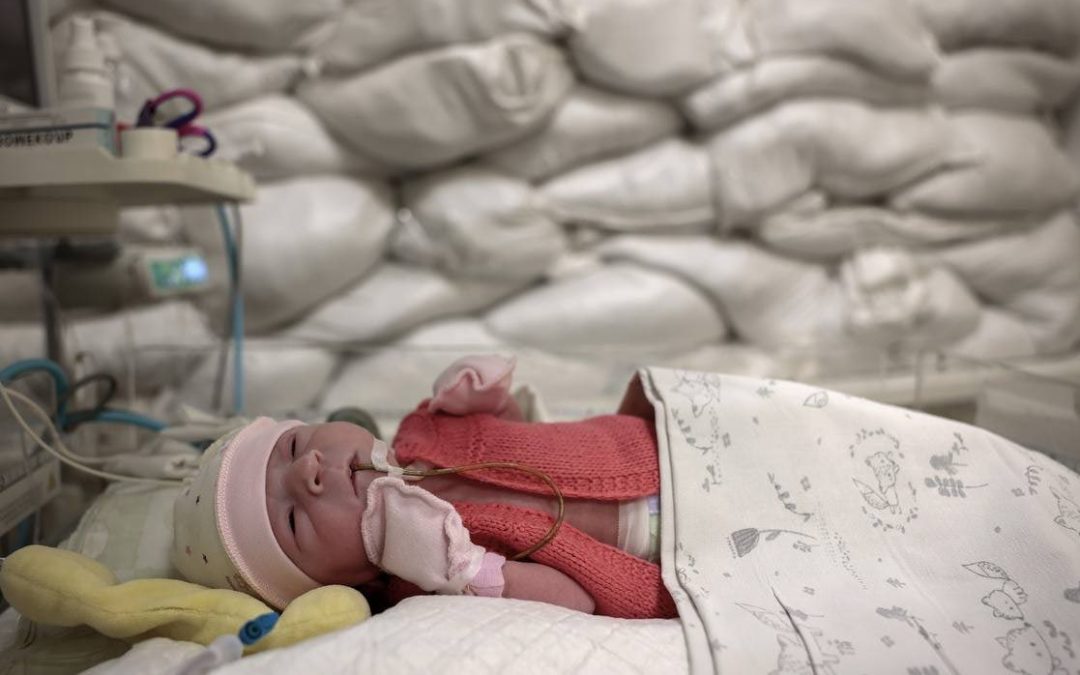 Baby in intensive care with sand bags in the window.